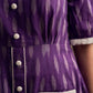 Purple Ikat dress with a notch collar, softly gathered sleeves, crisp white accents, a gently gathered upper waist, and functional slip-in pockets.