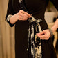 Chic black overlapping blazer-style wrap dress featuring printed black-and-white collar, cuffs, tie detail, and subtle accents