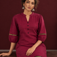 Elegant Maroon Silk Co-Ord Set with Contrast Black & Gold Border Detailing on Hem and Sleeves — seated detail
