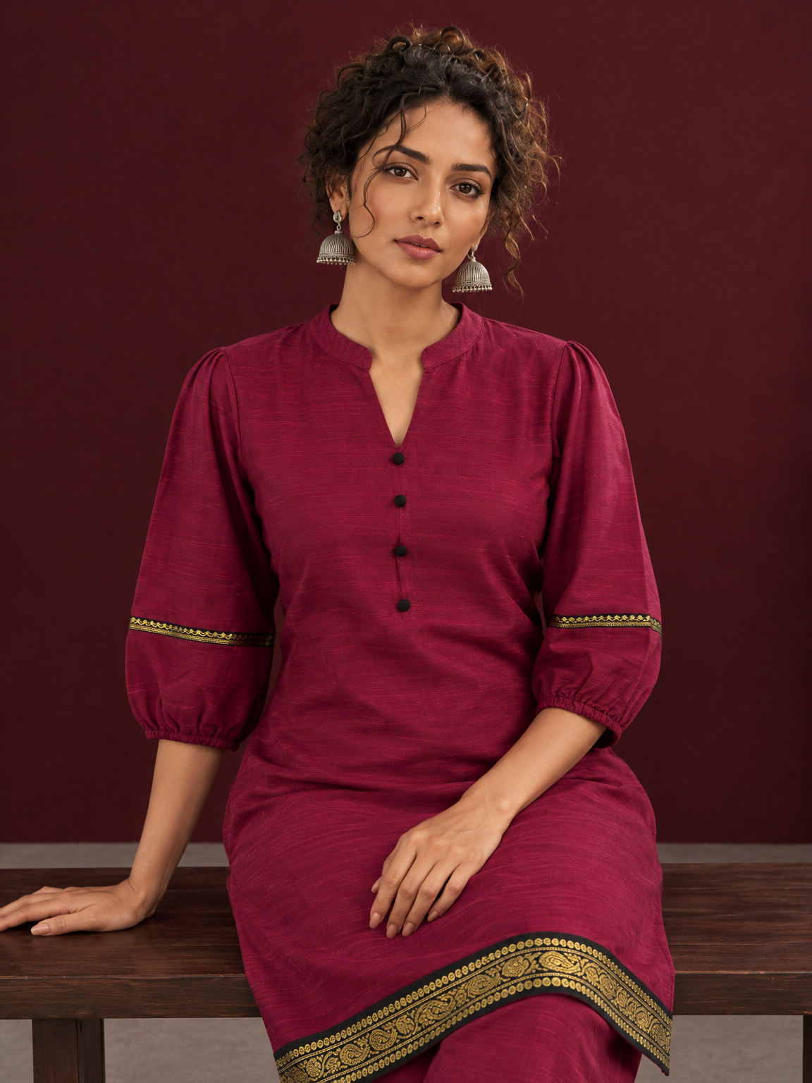 Elegant Maroon Silk Co-Ord Set with Contrast Black & Gold Border Detailing on Hem and Sleeves — seated detail