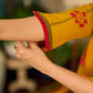 Mustard block printed pintuck dress with hand block red and pink vine floral motifs, accented with red and olive details for a rich, elegant look.