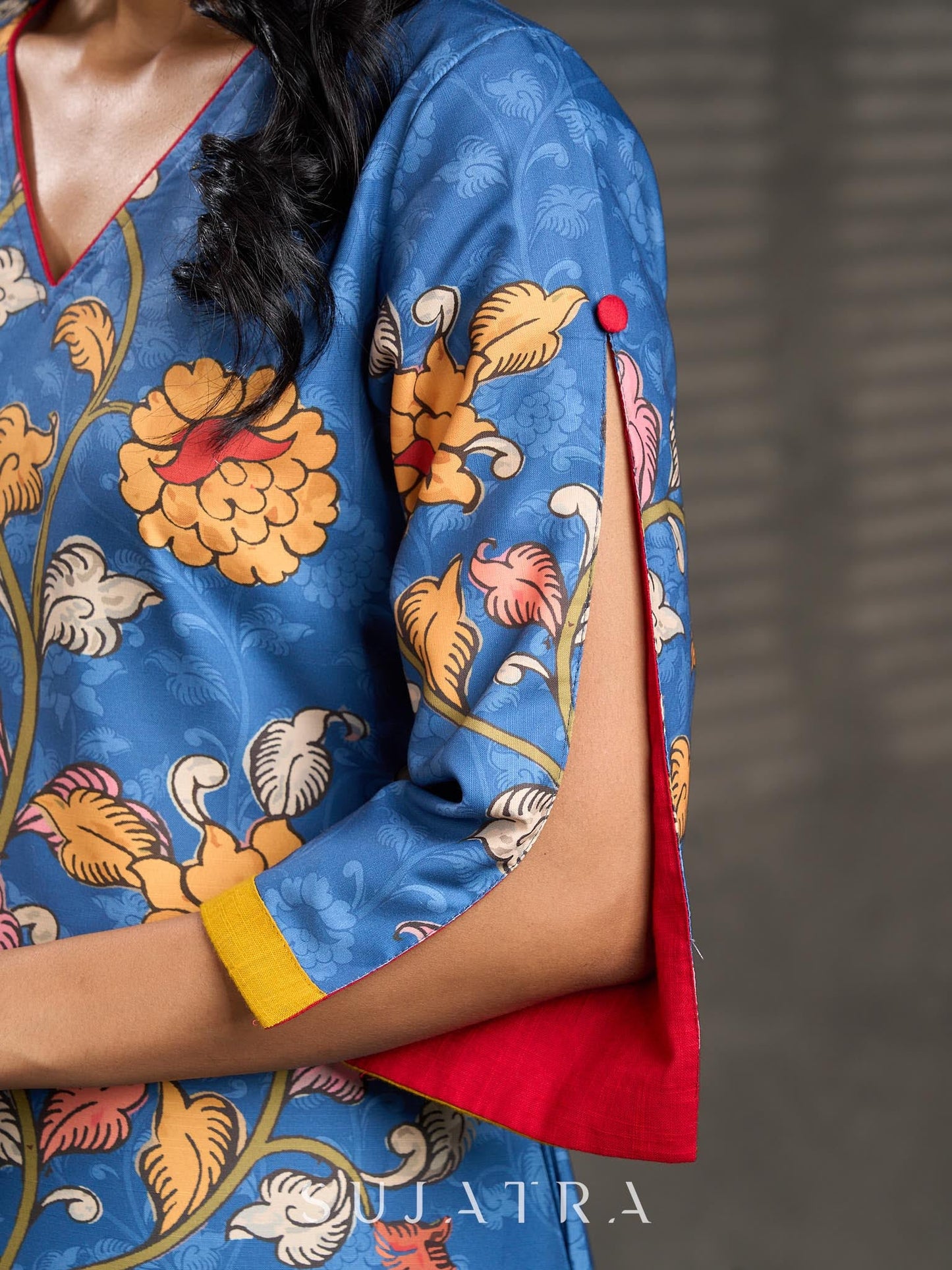 Indigo Kalamkari printed dress with vibrant red and mustard accents.
