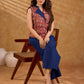Sharp sleeveless red Kalamkari overlap jacket with a statement one-sided flap, Chinese collar, and navy accents, offering a clean, structured silhouette ideal for elevated corporate styling.