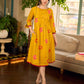 Mustard block printed pintuck dress with hand block red and pink vine floral motifs, accented with red and olive details for a rich, elegant look.