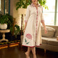 Off-white dandelion pleated shirt dress featuring dandelion placement block prints, checkered block-printed collar and cuffs, and red accents for a fresh, artisanal everyday look.