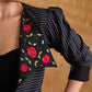 Exquisite black Ikat jacket with offset collar flaps and detailed red floral vine embroidery, delivering a sculpted, high-impact silhouette with refined presence for corporate styling.