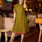 Gorgeous olive dress with pink abstract triangle hand block prints placed at the centre, sleeves, and back, featuring a mandarin collar and half sleeves for a refined, contemporary look.
