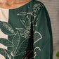 Bottle green and beige half and half dress with raglan sleeves and transitioning floral motifs.