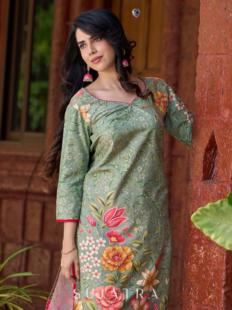 Soft green printed kurta with vibrant floral motifs, highlighted with hand embroidery and bright magenta accents.