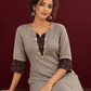 Elegant Beige Ajrakh Striped Cotton Kurta with Contrast Black Floral patch in Neckline & Sleeve Cuffs — seated detail
