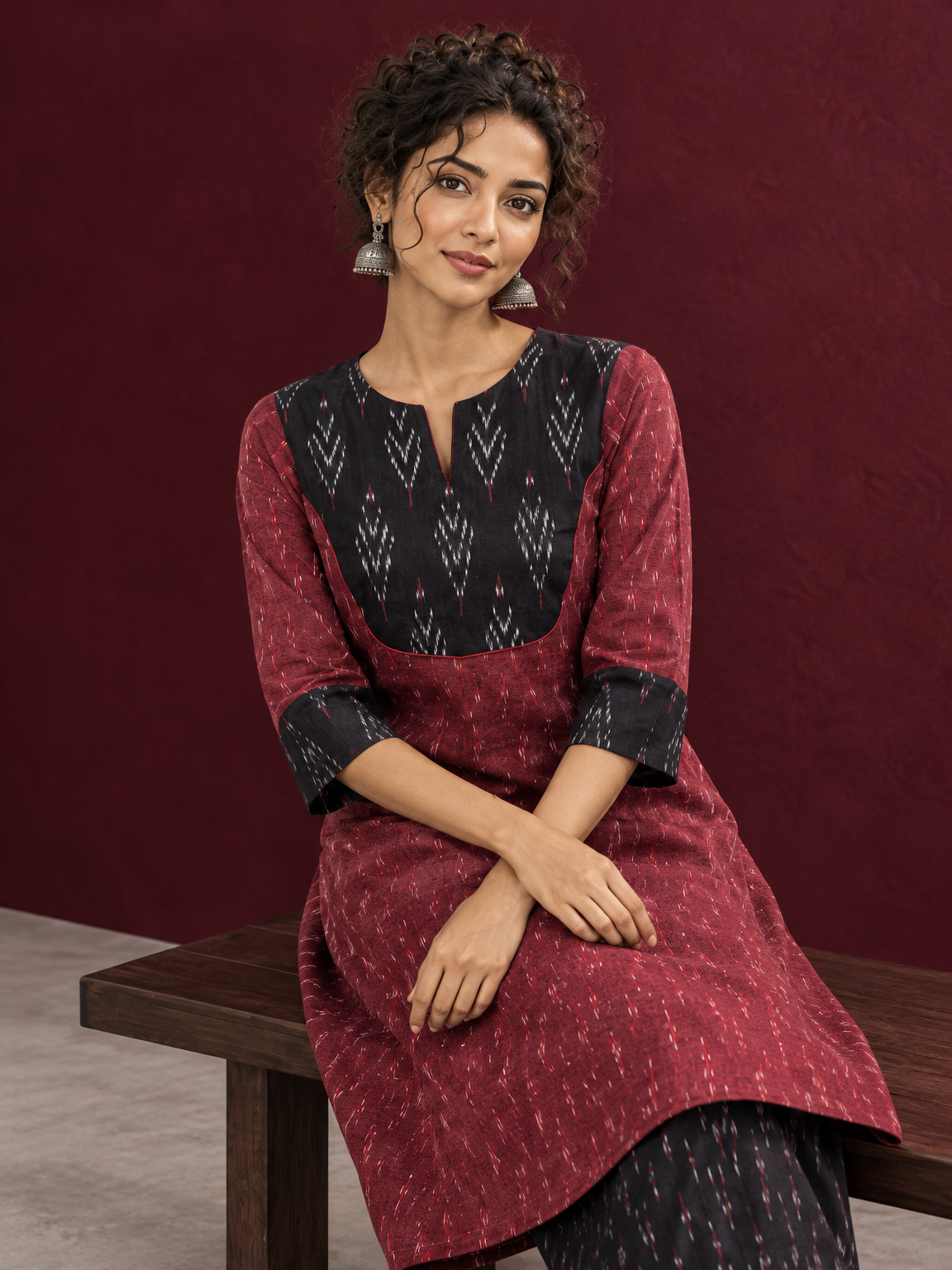 Elegant Maroon Ikat Cotton A Line Kurta With Black Yoke & Ikat Cuff Detailing — seated detail
