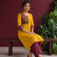 Mustard Yellow Cotton Kurta with Contrast Ajrakh Striped Yoke Panel & Coordinated Sleeve Cuffs — seated