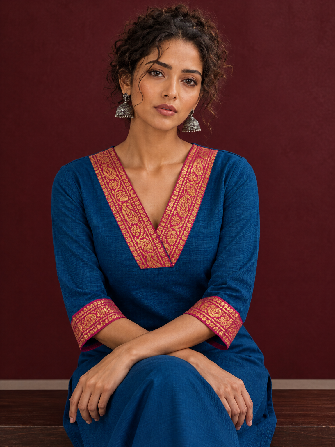 Elegant Peacock Blue Cotton Kurta with Contrast Pink & Gold Woven Border Neckline and Matching Salwar — seated detail