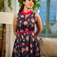Elegant black Kalamkari dress featuring blooming florals and contrasting pink detailing for refined charm.
