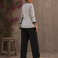 Black and white printed crossover top with contrast polka dots, lace-trimmed sleeves, side tie, tassels, and scalloped hem.