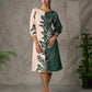 Bottle green and beige half and half dress with raglan sleeves and transitioning floral motifs.