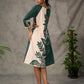 Bottle green and beige half and half dress with raglan sleeves and transitioning floral motifs.