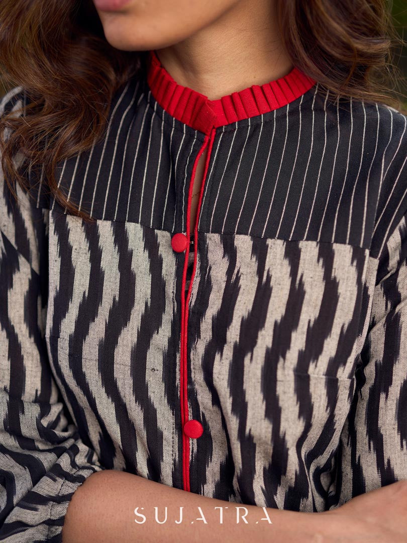 Black grey Ikat dress with soft frill detailing at the neckline, accented with red highlights, and finished with gentle gathers toward the bottom for a fluid silhouette