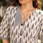 Modern white and grey Ikat shirt dress elevated with an asymmetrical checkered Ikat collar and contrast black accents.