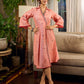 Peach dress featuring delicate Madhubani painting and graceful flared sleeves.