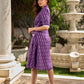 Purple Ikat dress with a notch collar, softly gathered sleeves, crisp white accents, a gently gathered upper waist, and functional slip-in pockets.