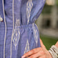 Graceful powder blue Ikat dress showcasing layered overlap details highlighted with white accents.