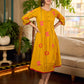 Mustard block printed pintuck dress with hand block red and pink vine floral motifs, accented with red and olive details for a rich, elegant look.