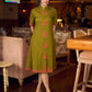 Gorgeous olive dress with pink abstract triangle hand block prints placed at the centre, sleeves, and back, featuring a mandarin collar and half sleeves for a refined, contemporary look.
