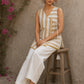 Charming white and mustard sleeveless wrap top featuring a distinctive Block print pattern, elegant mustard piping, and a graceful, contemporary, artisan-inspired tailored silhouette.