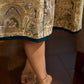 Artisanal beige Madhubani dress featuring intricate motifs, a contrasting green yoke, and refined accents.