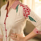 Off-white dandelion pleated shirt dress featuring dandelion placement block prints, checkered block-printed collar and cuffs, and red accents for a fresh, artisanal everyday look.
