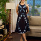 Black tie dye contemporary sleeveless dress with a bold, symmetrical dye pattern.