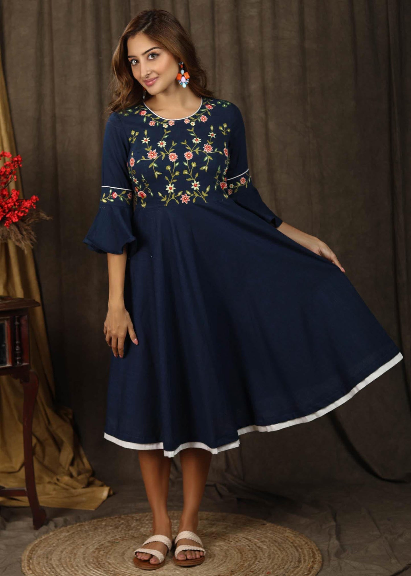 Classic navy blue gathered dress with bell sleeves and minimal floral embroidery