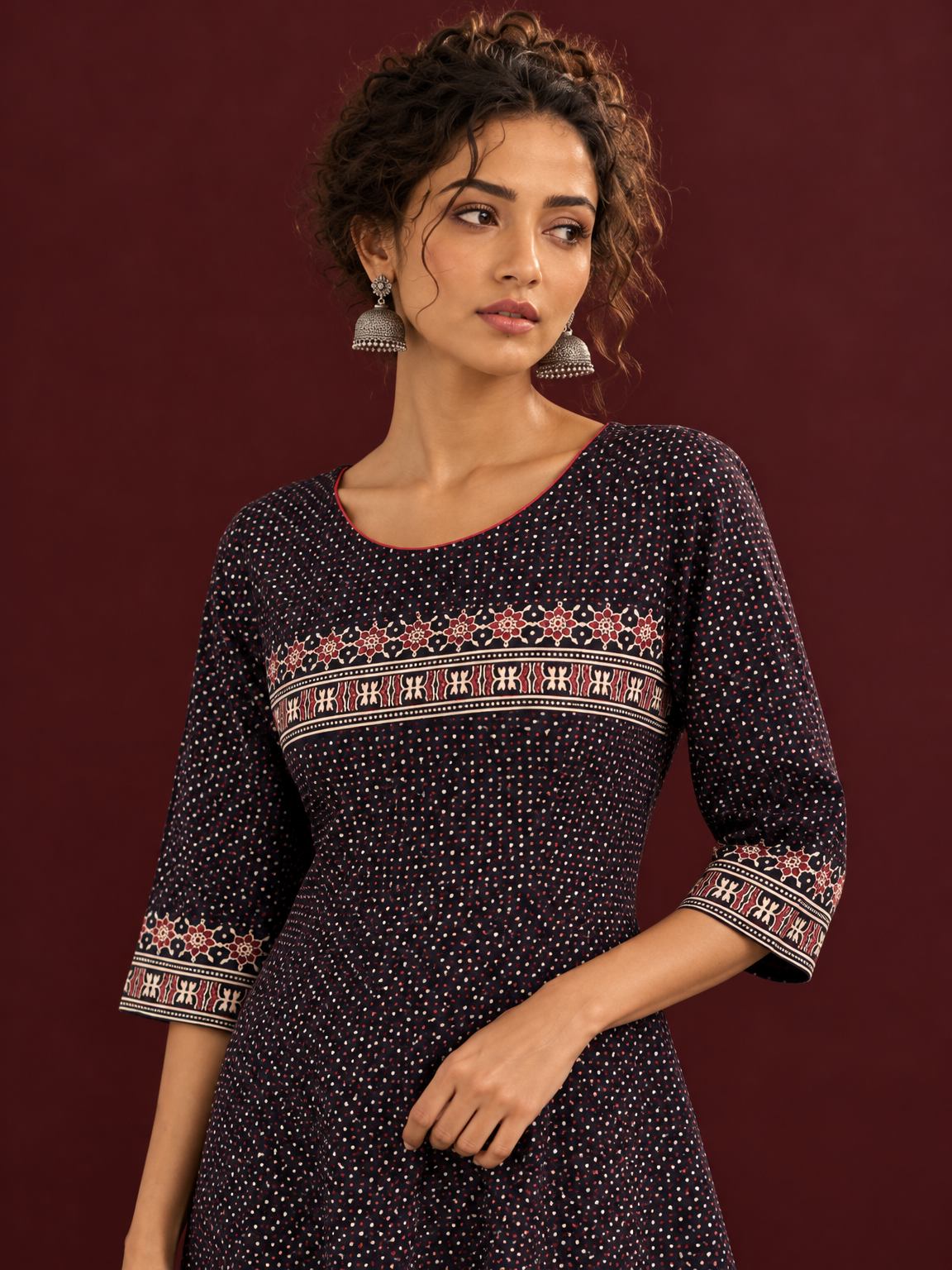 Elegant Black Ajrakh Polka Dot Printed Dress with Maroon Ajrakh Floral Border Yoke and Matching Sleeve Cuffs — fabric detail