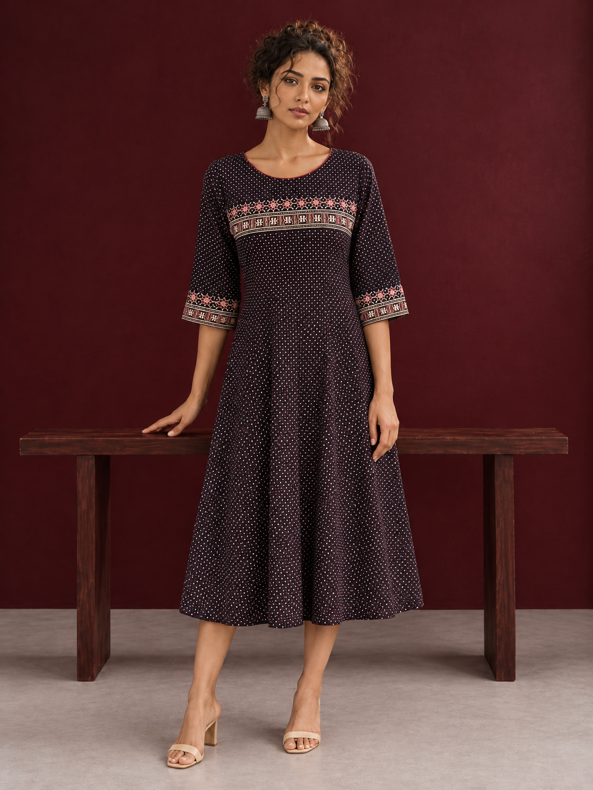 Elegant Black Ajrakh Polka Dot Printed Dress with Maroon Ajrakh Floral Border Yoke and Matching Sleeve Cuffs — front view