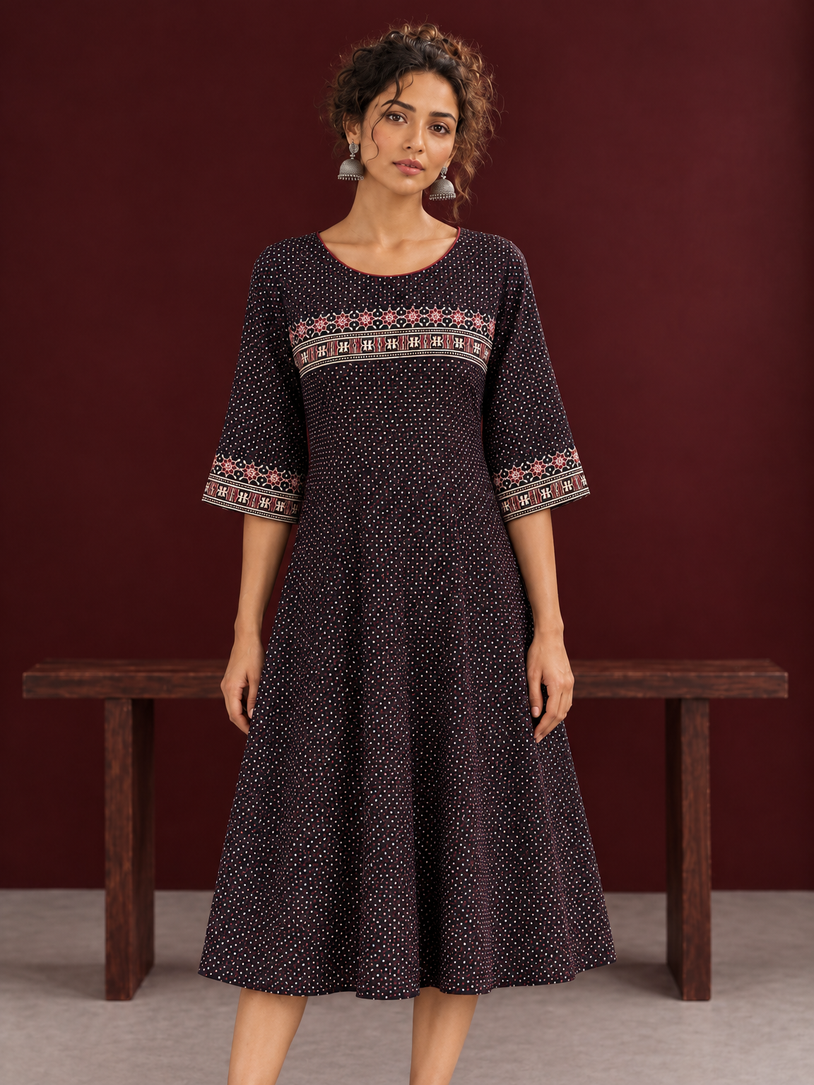 Elegant Black Ajrakh Polka Dot Printed Dress with Maroon Ajrakh Floral Border Yoke and Matching Sleeve Cuffs — styled view