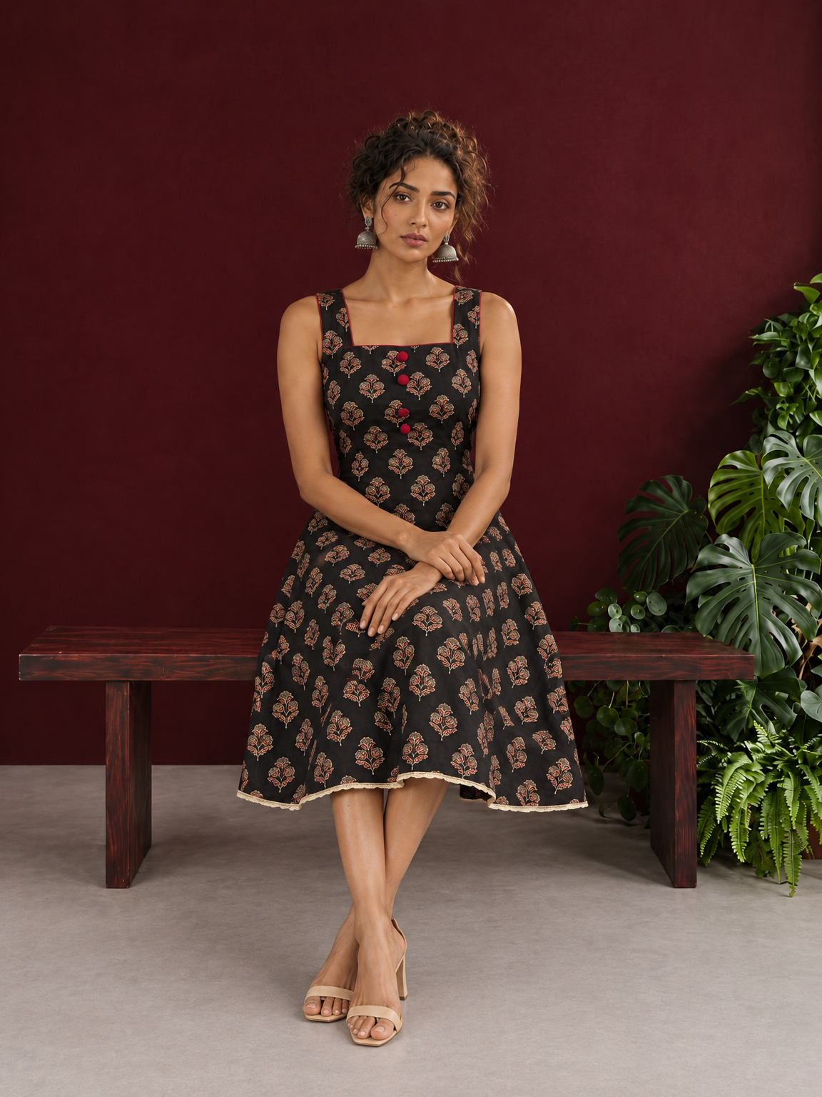 Classic Black Ajrakh Cotton Sleeveless Dress with Floral Print and Maroon Piping Square Neckline — seated