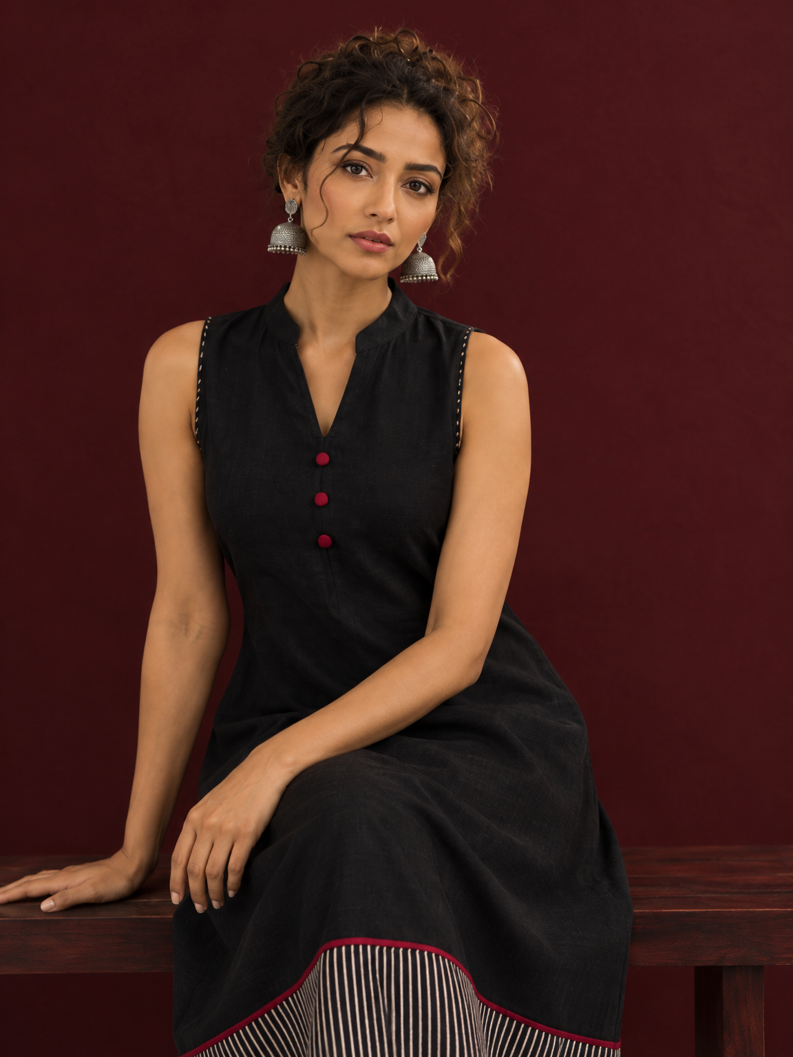 Timeless Black Cotton Sleeveless One Piece Dress with Mandarin Collar & Contrast Ajrakh Striped Hemline Panel — seated detail