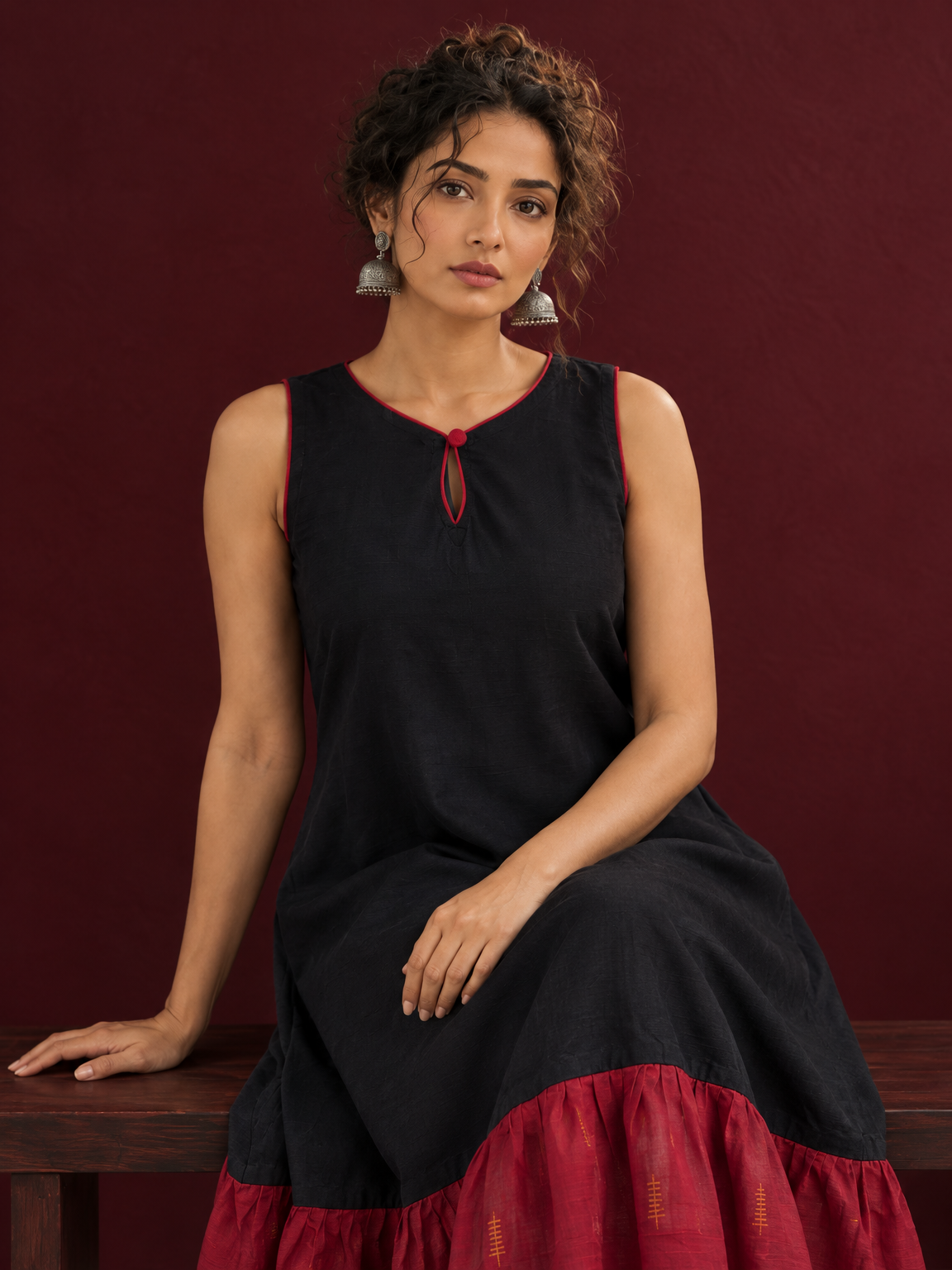 Classic Black Cotton Silk Dress with Keyhole Neckline and Contrast Maroon Ruffle Hem — seated detail
