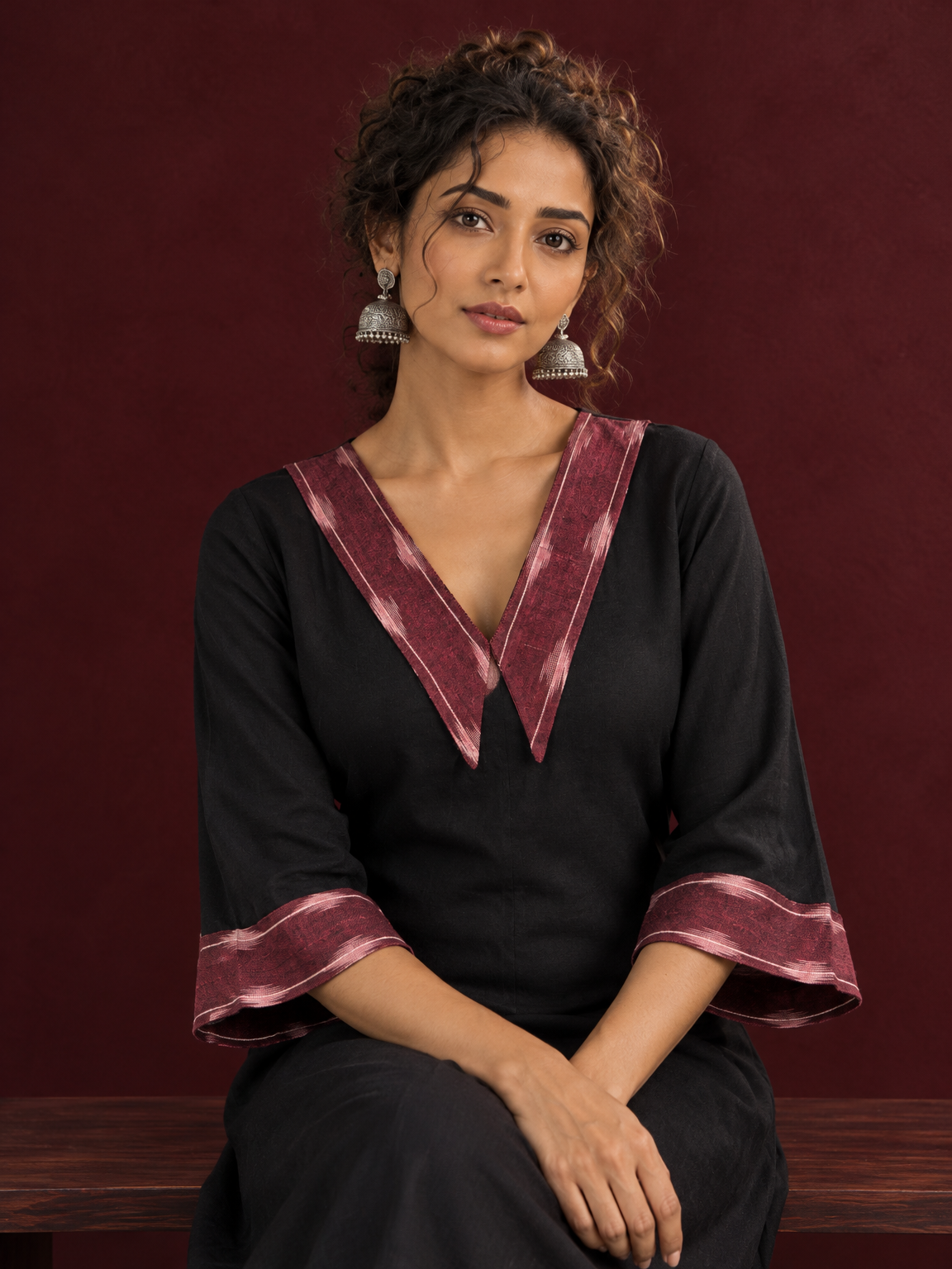 Classic Black Cotton A-line Dress with Contrast Maroon Ikat Collar and Matching Sleeve Cuffs — seated detail