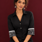 Classic Black Cotton Shirt with Collared Neckline and Contrast Printed Sleeve Cuffs — seated detail