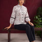 White Cotton Shirt with Warli Print, Mandarin Collar & Crochet Trimmed Full Sleeves — seated
