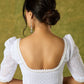 Elegant white blouse with chikankari, moti embroidery, and lace.