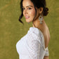 Elegant white blouse with chikankari, moti embroidery, and lace.