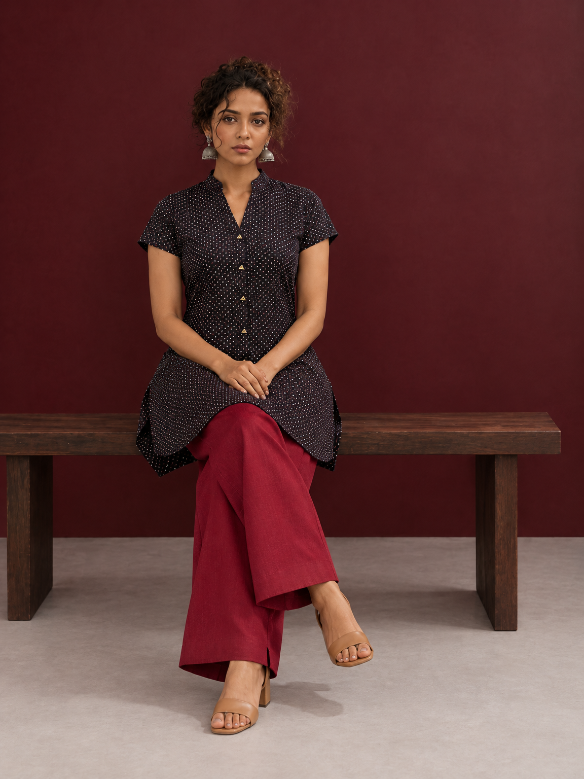 Timeless Black Cotton Tunic with Maroon Polka Dot Print and Gold Triangle Button Placket — seated