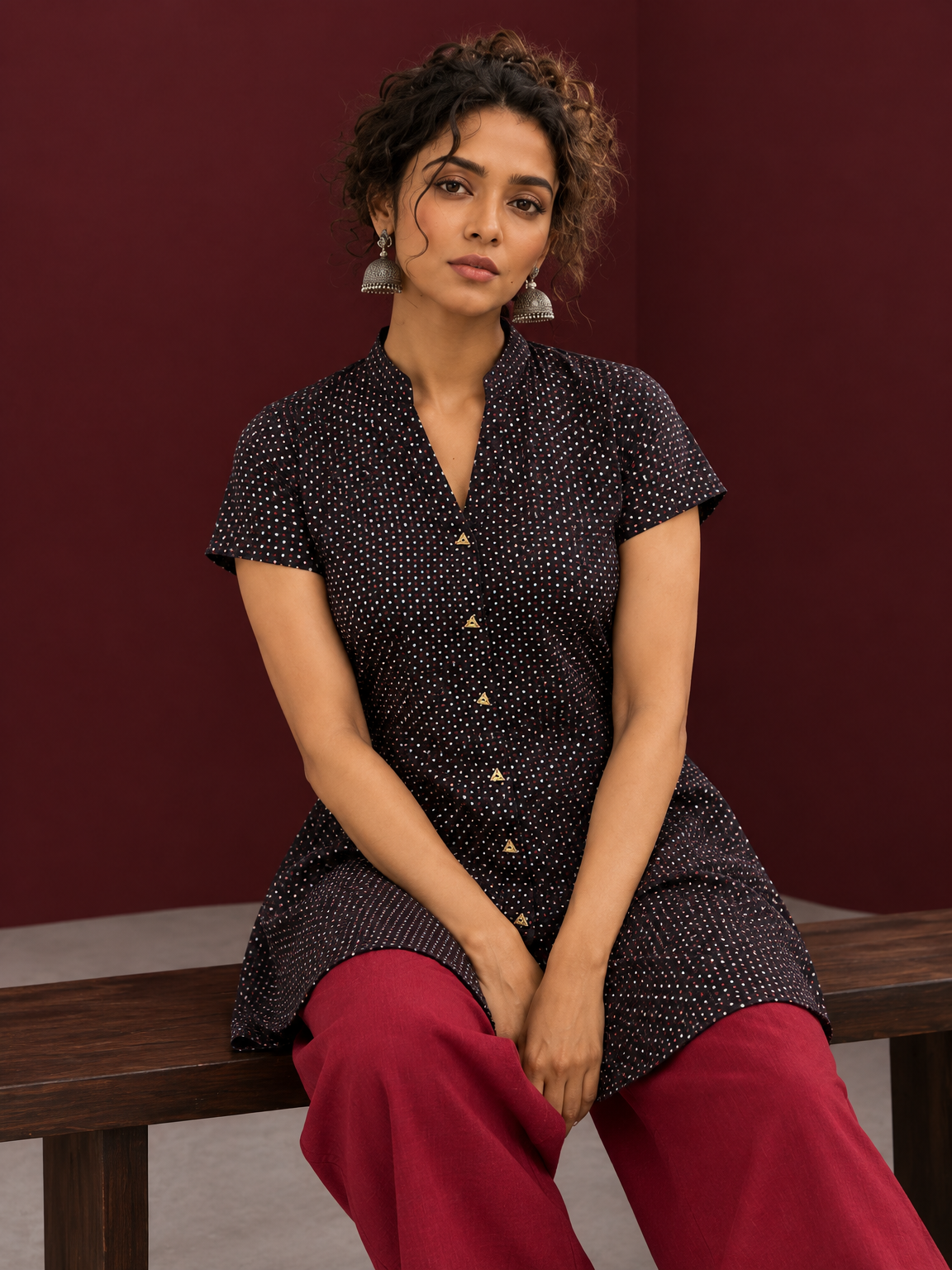 Timeless Black Cotton Tunic with Maroon Polka Dot Print and Gold Triangle Button Placket — seated detail