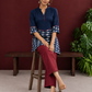 Navy Blue Cotton Tunic with Fish Print Hem Panel, Contrast Maroon Piping & Red Button Detail — seated