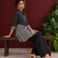 Classic Black & White Pinstripe Tunic with Contrast Striped Panel and Mandarin Collar — seated