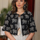 Ivory ikat dress with black cow print attached jacket and coin embellishments