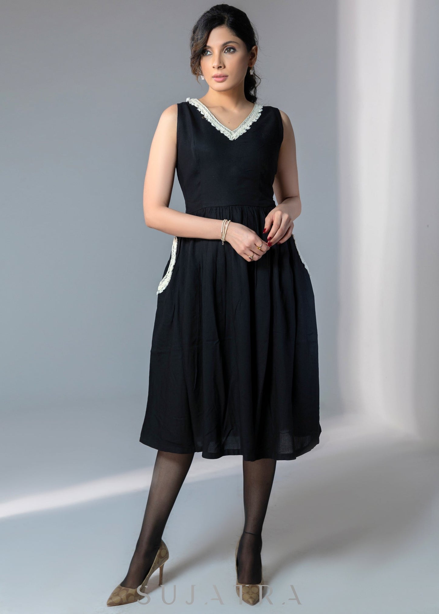 Black sleeveless rayon dress with off white lace detailing on neck and pockets